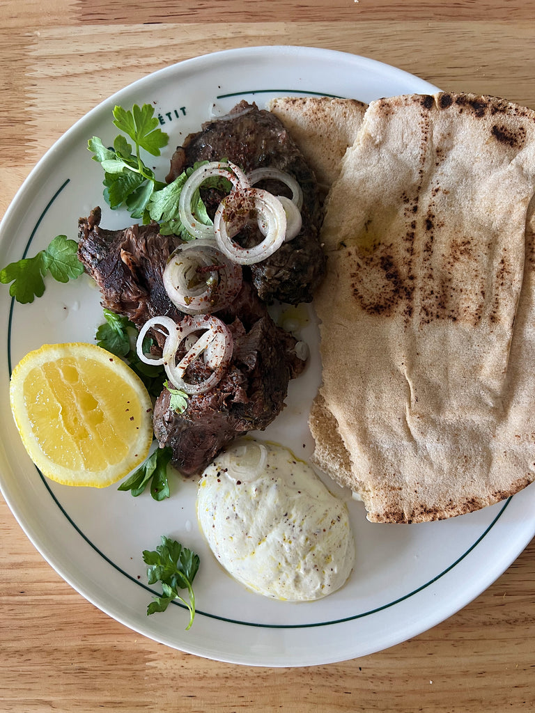 Slow cooked goat shoulder with sumac lemon yoghurt and pita